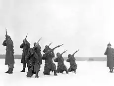 Members of C Company, 9th Engineers, conduct a memorial service for those killed during the siege, 22 January 1945.